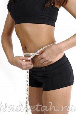 5676421-a-tanned-slim-young-woman-measuring-her-waistline.jpg